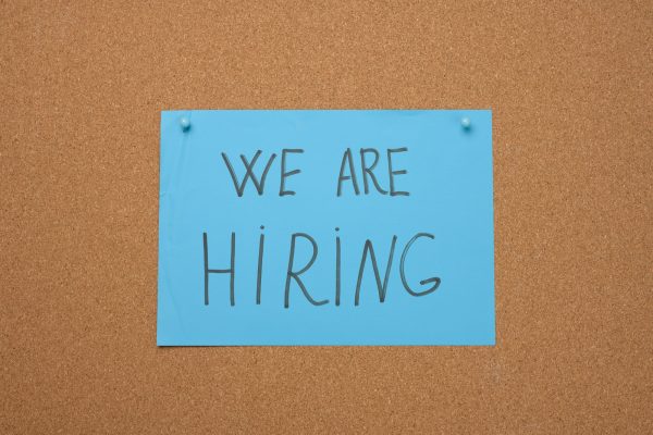Blue sheet of paper with an inscription on a brown cork board. Recruitment concept, vacancy